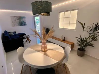 a white table and chairs in a living room at Amelia luxury beachfront apartment near airport in Porto Rafti