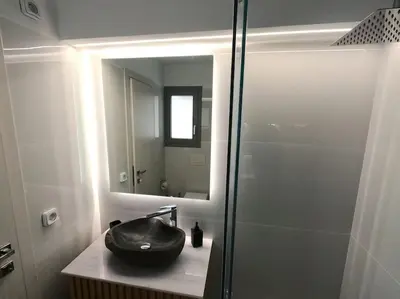 a bathroom with a black sink and a mirror at Amelia luxury beachfront apartment near airport in Porto Rafti
