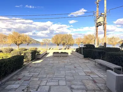 a patio with benches and a view of the water at Amelia luxury beachfront apartment near airport in Porto Rafti