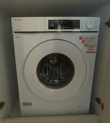 a white washing machine sitting in a room at Amelia luxury beachfront apartment near airport in Porto Rafti