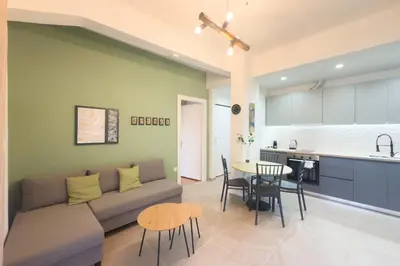 a living room with a couch and a table and a kitchen at Panormou Neon - Urban Apartment 2B in Athens