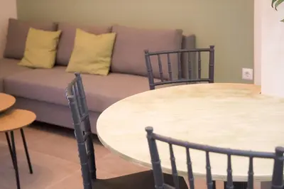 a living room with a couch and a table and chairs at Panormou Neon - Urban Apartment 2B in Athens