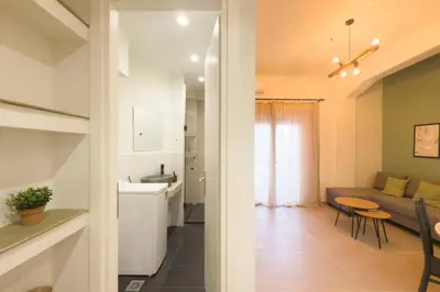 a kitchen and living room with a couch and a table at Panormou Neon - Urban Apartment 2B in Athens