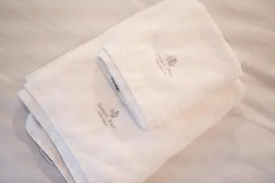 a white towel sitting on top of a bed at Panormou Neon - Urban Apartment 2B in Athens