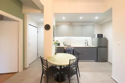 a kitchen and dining room with a table and chairs at Panormou Neon - Urban Apartment 2B in Athens