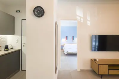 a room with a clock on the wall and a bedroom at Panormou Neon - Urban Apartment 2A in Athens