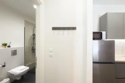 a white bathroom with a toilet and a refrigerator at Panormou Neon - Urban Apartment 2A in Athens