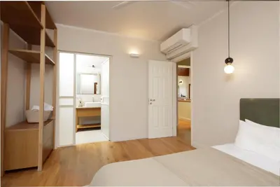 a white bedroom with a bed and a bathroom at Villa Lithos in Porto Rafti