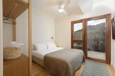a bedroom with a bed and a large window at Villa Lithos in Porto Rafti