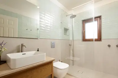 a bathroom with a sink and a toilet and a shower at Villa Lithos in Porto Rafti