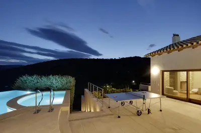 a patio with a ping pong table and a pool at Villa Lithos in Porto Rafti