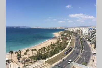 a view of a beach with palm trees and the ocean at Roof Top appartement with huge Terrace in Athens
