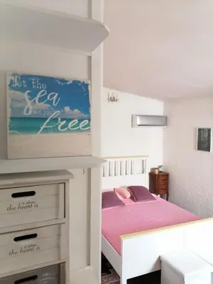 a small bedroom with a bed with pink sheets at Roof Top appartement with huge Terrace in Athens