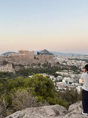 a person taking a picture of the acropolis from a mountain at Bright Koukaki Studio -10 min Walk to Acropolis in Athens