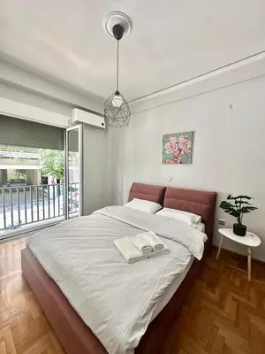 a bedroom with a large bed and a potted plant at Modern stay-10 mins from the city center- 5 mins from the beach in Athens