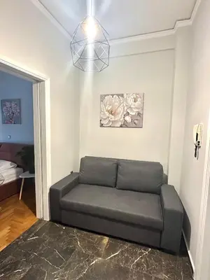 a living room with a couch in a room at Modern stay-10 mins from the city center- 5 mins from the beach in Athens
