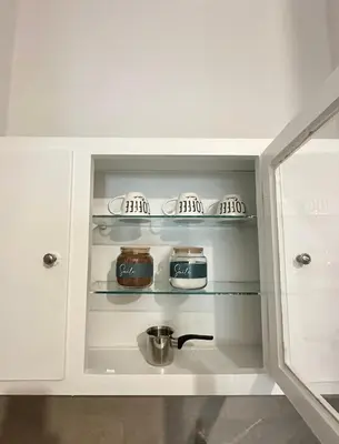 a kitchen with white cabinets with pots and pans at Modern stay-10 mins from the city center- 5 mins from the beach in Athens