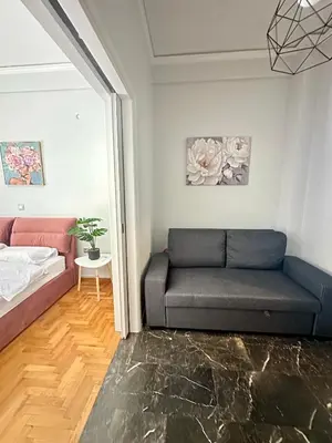a living room with a couch and a bed at Modern stay-10 mins from the city center- 5 mins from the beach in Athens