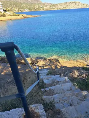 a gate with a rope leading to a body of water at Daskalio Waves Appartment Agapi in Dhaskalión