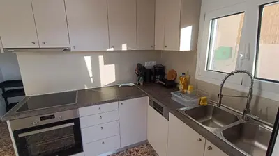 a kitchen with white cabinets and a sink at Daskalio Waves Appartment Agapi in Dhaskalión