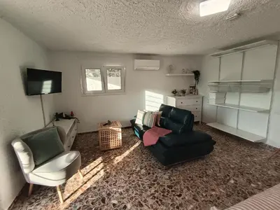 a living room with two chairs and a television at Daskalio Waves Appartment Agapi in Dhaskalión
