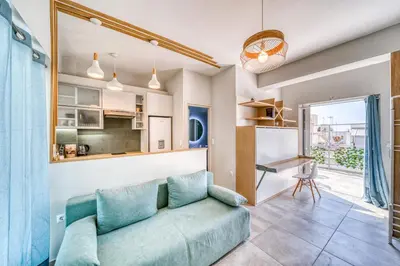 a living room with a couch and a kitchen at Acropolis View Studio Varnava in Athens