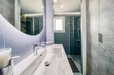 a bathroom with a sink and a shower and a mirror at Acropolis View Studio Varnava in Athens