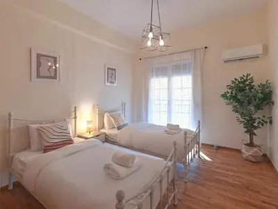 a bedroom with two beds and a window at Kalliannassa in Piraeus