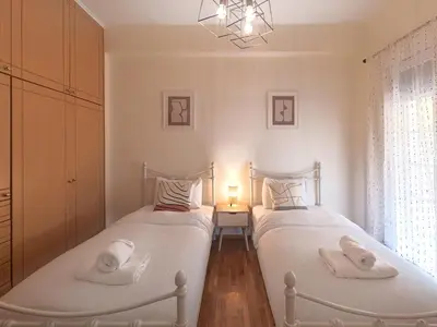 two twin beds in a bedroom with a lamp at Kalliannassa in Piraeus