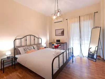 a bedroom with a bed and a desk and a mirror at Kalliannassa in Piraeus
