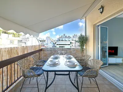 a table and chairs on a balcony with a view at Kalliannassa in Piraeus