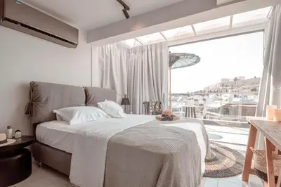 a bedroom with a bed and a large window at Penthouse Studio Acropolis View in Athens