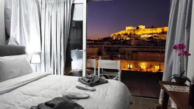 a bedroom with a bed and a view of a city at Penthouse Studio Acropolis View in Athens
