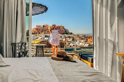 a woman standing on a balcony looking out at the city at Penthouse Studio Acropolis View in Athens
