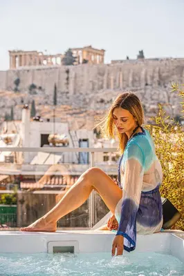 a woman sitting on the edge of a bath tub at Penthouse Studio Acropolis View in Athens