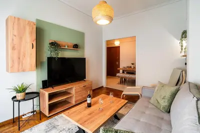a living room with a couch and a flat screen tv at Serica Apartment in Athens