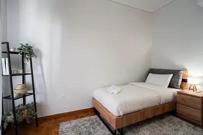 a small bedroom with a bed and a shelf at Serica Apartment in Athens