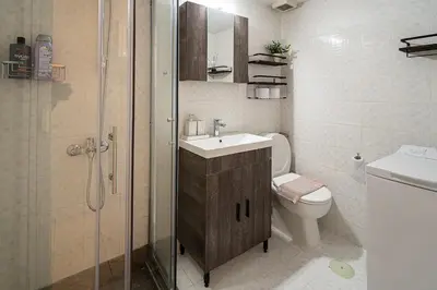 a bathroom with a toilet and a sink and a shower at Serica Apartment in Athens