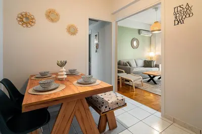 a dining room with a table and a living room at Serica Apartment in Athens