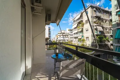 a balcony with a table and a chair and some buildings at Serica Apartment in Athens