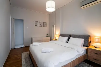 a bedroom with a large white bed with two towels on it at Serica Apartment in Athens