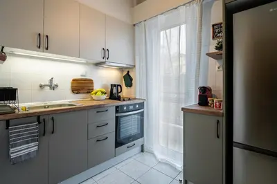 a kitchen with white cabinets and a sink at Serica Apartment in Athens