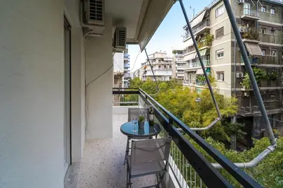 a balcony with a blue table and chairs and buildings at Serica Apartment in Athens