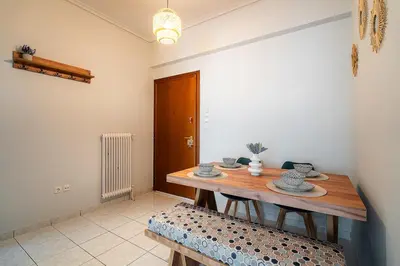 a dining room with a wooden table and a bench at Serica Apartment in Athens