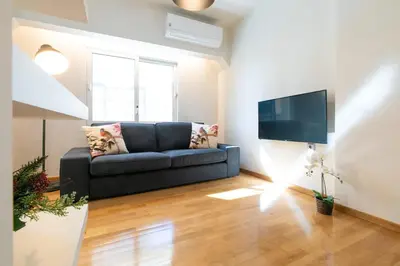 a living room with a couch and a flat screen tv at Spacious Central Apartment Close to Metro in Athens