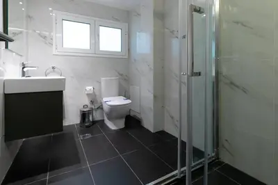 a bathroom with a toilet and a sink and a shower at Spacious Central Apartment Close to Metro in Athens