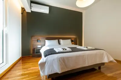 a bedroom with a large bed with a black wall at Spacious Central Apartment Close to Metro in Athens