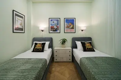 two beds in a room with pictures on the wall at 2 BR Apartment with Sitcom Vibes VIPGreece in Athens