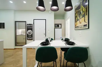 a dining room with a white table and green chairs at 2 BR Apartment with Sitcom Vibes VIPGreece in Athens