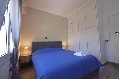 a bedroom with a blue bed and white cabinets at The North - Floor apartment in Kato Halandri in Athens